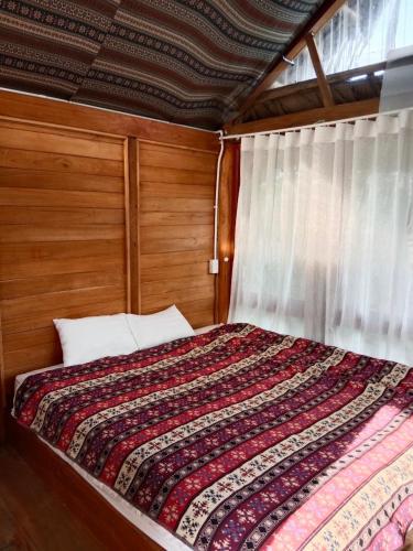 a bedroom with a bed with a quilt on it at Hali Home Moc Chau in Mộc Châu