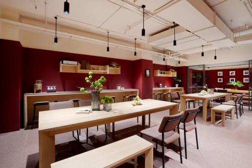 un restaurante con mesas, sillas y paredes rojas en base-Beijing Wangfujing Serviced Apartment, en Beijing