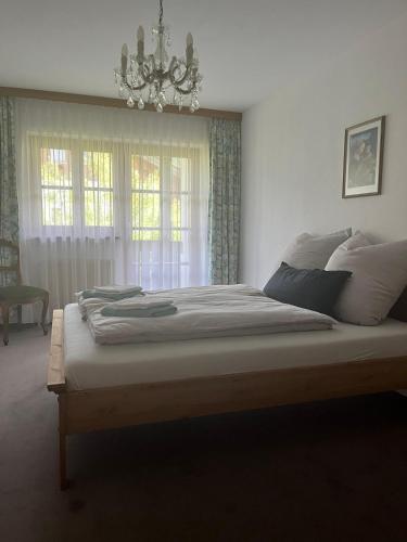 a bedroom with a large bed with a chandelier at Ferienhaus Reseda in Bayerisch Gmain