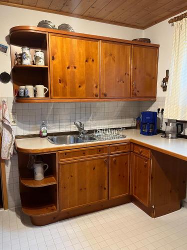 a kitchen with wooden cabinets and a sink at Ferienhaus Reseda in Bayerisch Gmain