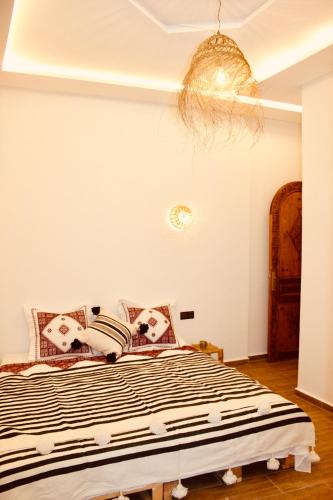a bedroom with a bed with a black and white comforter at TRAVEL SURF NATURE in Tamraght Ouzdar