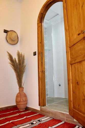 an open door in a room with a vase at TRAVEL SURF NATURE in Tamraght Ouzdar