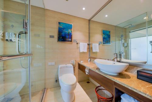 a bathroom with a sink and a toilet and a shower at Zhengzhou Yuehai Hotel in Zhengzhou