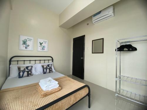 a bedroom with a bed with a towel on it at Cebu One Pavillion Place by P&J in Cebu City
