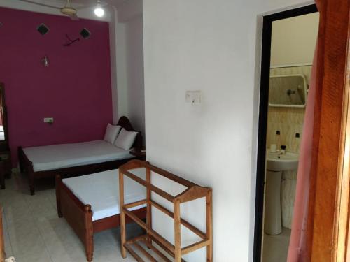 a small room with a bed and a sink at Sunila Family Rest Anuradhapura in Anuradhapura