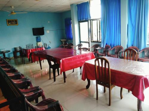 a dining room with tables and chairs with red table cloth at Sunila Family Rest Anuradhapura in Anuradhapura
