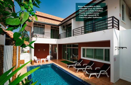a villa with a swimming pool in front of a building at TW Marina Pool Villa Pattaya in Pattaya South