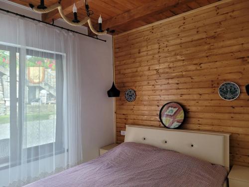 Un dormitorio con una cama y una pared de madera. en MaDaS, en Bărbăteşti