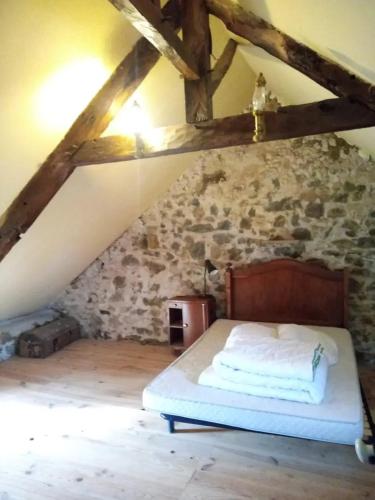 une chambre avec un lit dans un grenier dans l'établissement La Maison de Port à la Duc, à Pléboulle