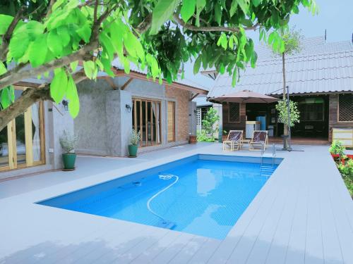 a swimming pool in the backyard of a house at Greyhouse Homestay in Ban Umeng