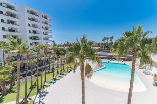 - Vistas a la piscina del complejo, con palmeras en Home2Book Stylish Apartment Playa del Inglés, en Maspalomas