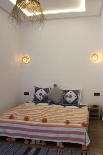 a bedroom with a bed with blue and white pillows at TRAVEL SURF NATURE in Tamraght Ouzdar
