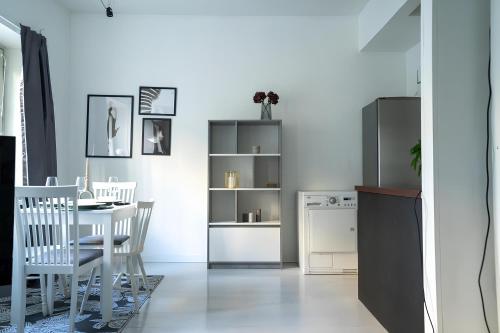 a dining room with a white table and chairs at Stylish Studio at the Heart of Helsinki in Helsinki