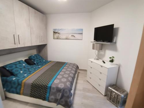 een kleine slaapkamer met een bed en een televisie bij Coquet 2 pièces entièrement rénové et climatisé in Cannes