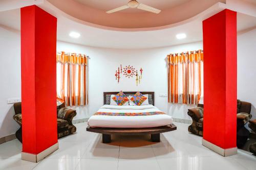 a room with a bed with red columns at FabExpress Sai Lodging in Nashik