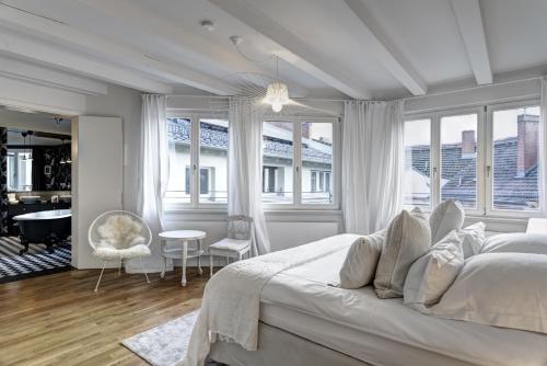 a white bedroom with a large bed and windows at Gorki Apartments in Berlin