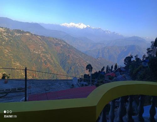 uma vista para um vale com montanhas ao fundo em Rinchen Ghising Homestay by StayApart em Ghum