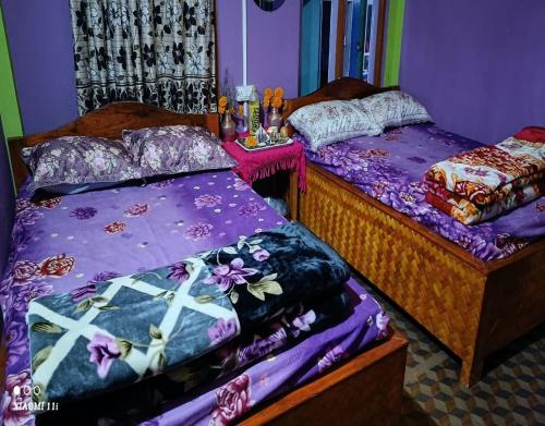 duas camas num quarto com lençóis roxos em Rinchen Ghising Homestay by StayApart em Ghum