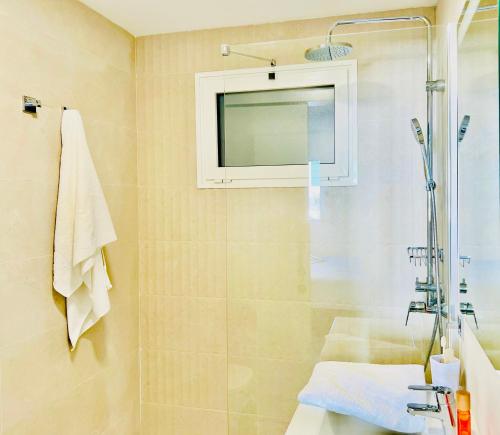 a bathroom with a shower and a tv on the wall at Canaryislandshost l Room in Playa Blanca