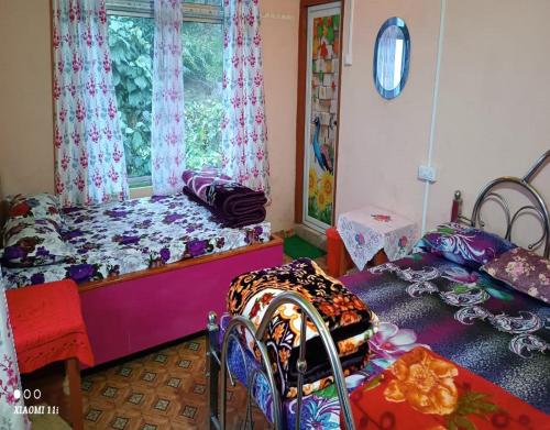 um quarto com 2 camas e uma janela em Rinchen Ghising Homestay by StayApart em Ghum