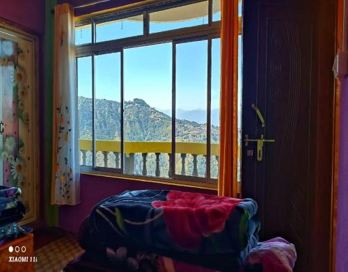 um quarto com uma janela com vista para uma montanha em Rinchen Ghising Homestay by StayApart em Ghum