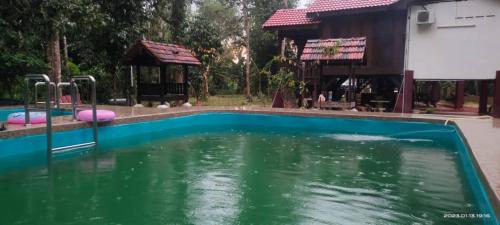 a pool of water with a playground and a house at SRI MALAU 