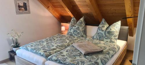 Schlafzimmer mit einem Bett mit blauer und weißer Bettwäsche und Kissen in der Unterkunft Apartment am Ammersee in Herrsching am Ammersee