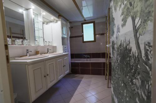 uma casa de banho com 2 lavatórios e uma banheira em Les Eaux Vives em Sévrier
