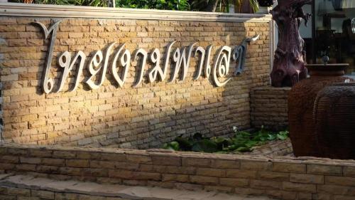 a brick wall with a sign that says addiction on it at โรงแรมไทยงามพาเลซ (Thai Ngam Palace Hotel) in Kaeng Khlo