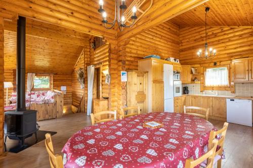 - une salle à manger et une cuisine dans une cabane en rondins dans l'établissement Chalet les deux marmottes - Vue montagne, à Bolquère-Pyrénées 2000