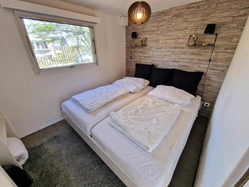een groot bed in een kamer met een raam bij Blue Ocean K40 in Makkum