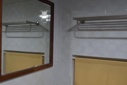 a mirror on a wall next to a bathroom at Zibro in Gunsan