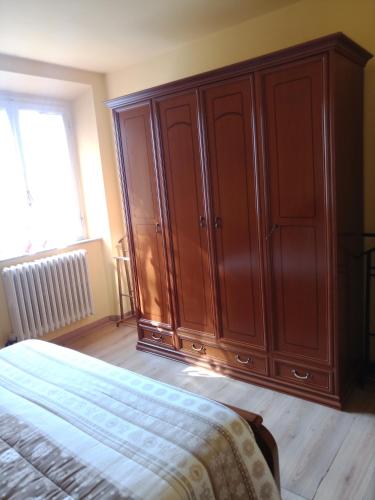 a bedroom with a large wooden cabinet next to a bed at Gli Aristogatti in Campo Tizzoro