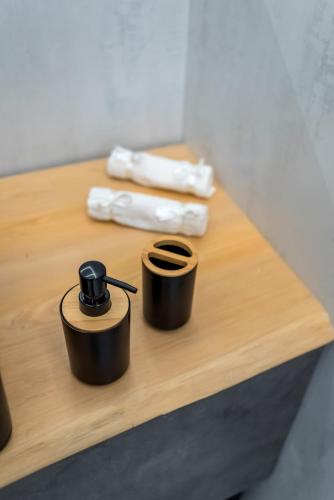 two containers on a wooden table with two towels at V.L.A Apartments by the sea in Vari