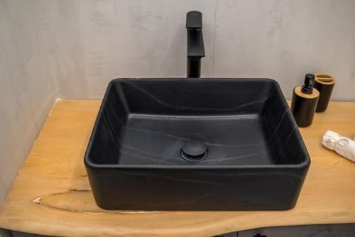 a black kitchen sink sitting on a wooden counter at V.L.A Apartments by the sea in Vari