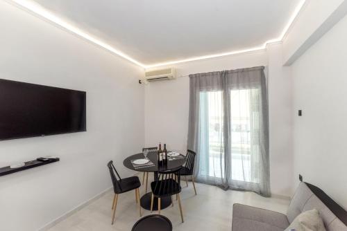 a living room with a table and a tv on a wall at V.L.A Apartments by the sea in Vari