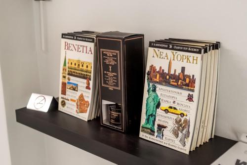 three books sitting on top of a shelf at V.L.A Apartments by the sea in Vari