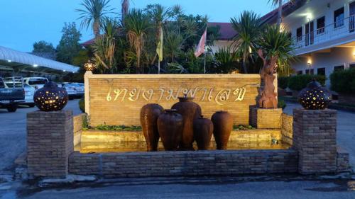 a statue of vases on a wall in front of a building at โรงแรมไทยงามพาเลซ (Thai Ngam Palace Hotel) in Kaeng Khlo