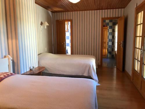 a hotel room with two beds and a hallway at Charming cottage, 10 minutes from Ax les Thermes in Unac