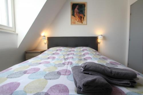 a bedroom with a bed with a colorful comforter at PEBE ART - COLMAR City center in Colmar