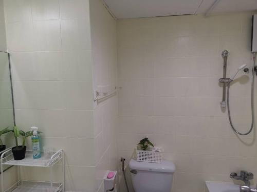 a white bathroom with a shower and a toilet at Tower Resident in the Heart of Bangkok Shopping Center in Makkasan