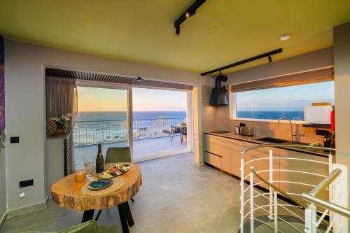 a kitchen and dining room with a view of the ocean at Salini Suites in Żebbuġ