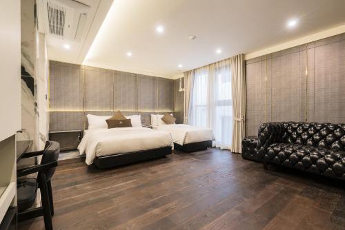 ein Hotelzimmer mit 2 Betten und einem Sofa in der Unterkunft HOTEL THE MAY Jongno in Seoul