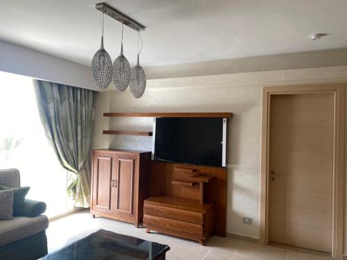 sala de estar con TV de pantalla plana en la pared en Il monte galala, en Ain Sokhna
