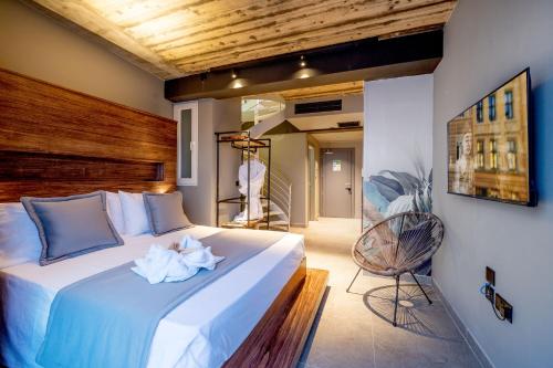 a bedroom with a large white bed with a wooden headboard at Salini Suites in Żebbuġ