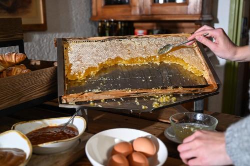a person is cutting a cake with a spoon at Rifugio Cereda in Fiera di Primiero