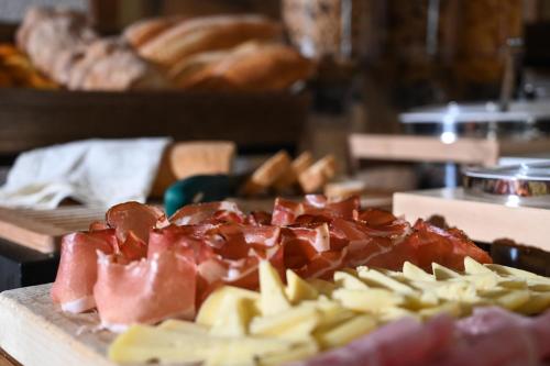 a cutting board with meat and cheese on a table at Rifugio Cereda in Fiera di Primiero