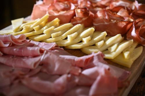 a group of meats and cheese on a cutting board at Rifugio Cereda in Fiera di Primiero