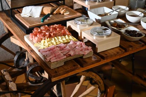 a table filled with different types of meats and cheese at Rifugio Cereda in Fiera di Primiero