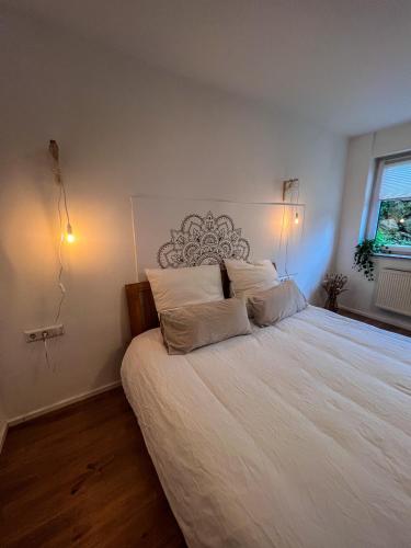 a bedroom with a large white bed with two pillows at Bergoase Relax&Spa in Unteropfingen